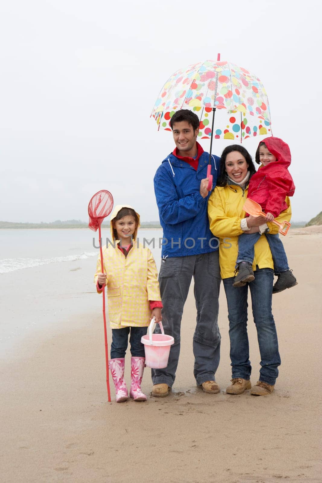 Happy family on beach with umbrella