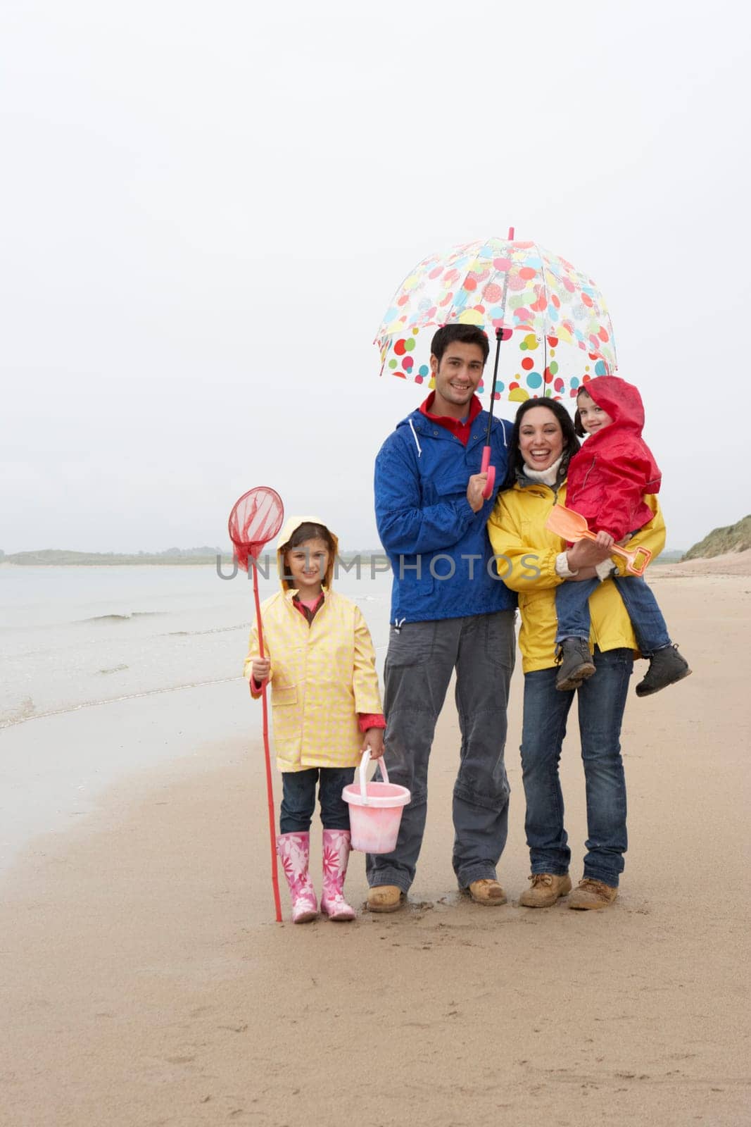Happy family on beach with umbrella