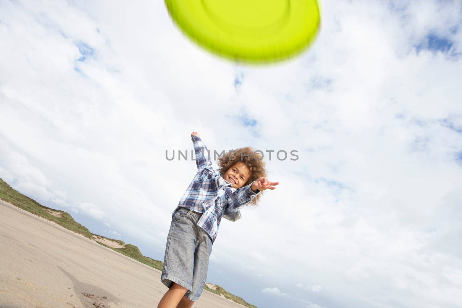 Boy playing frisbee on beach