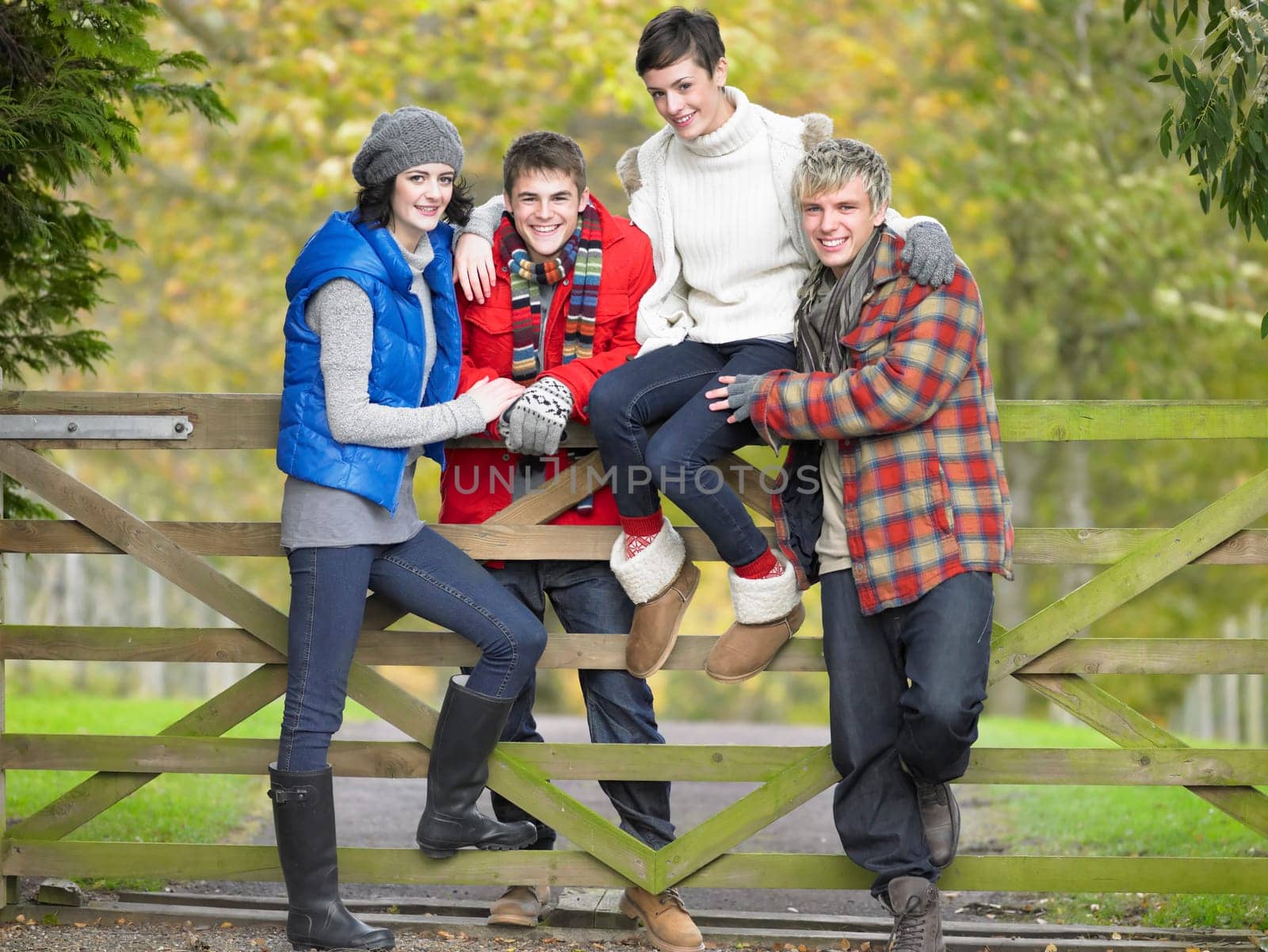 Young friends sitting on fence