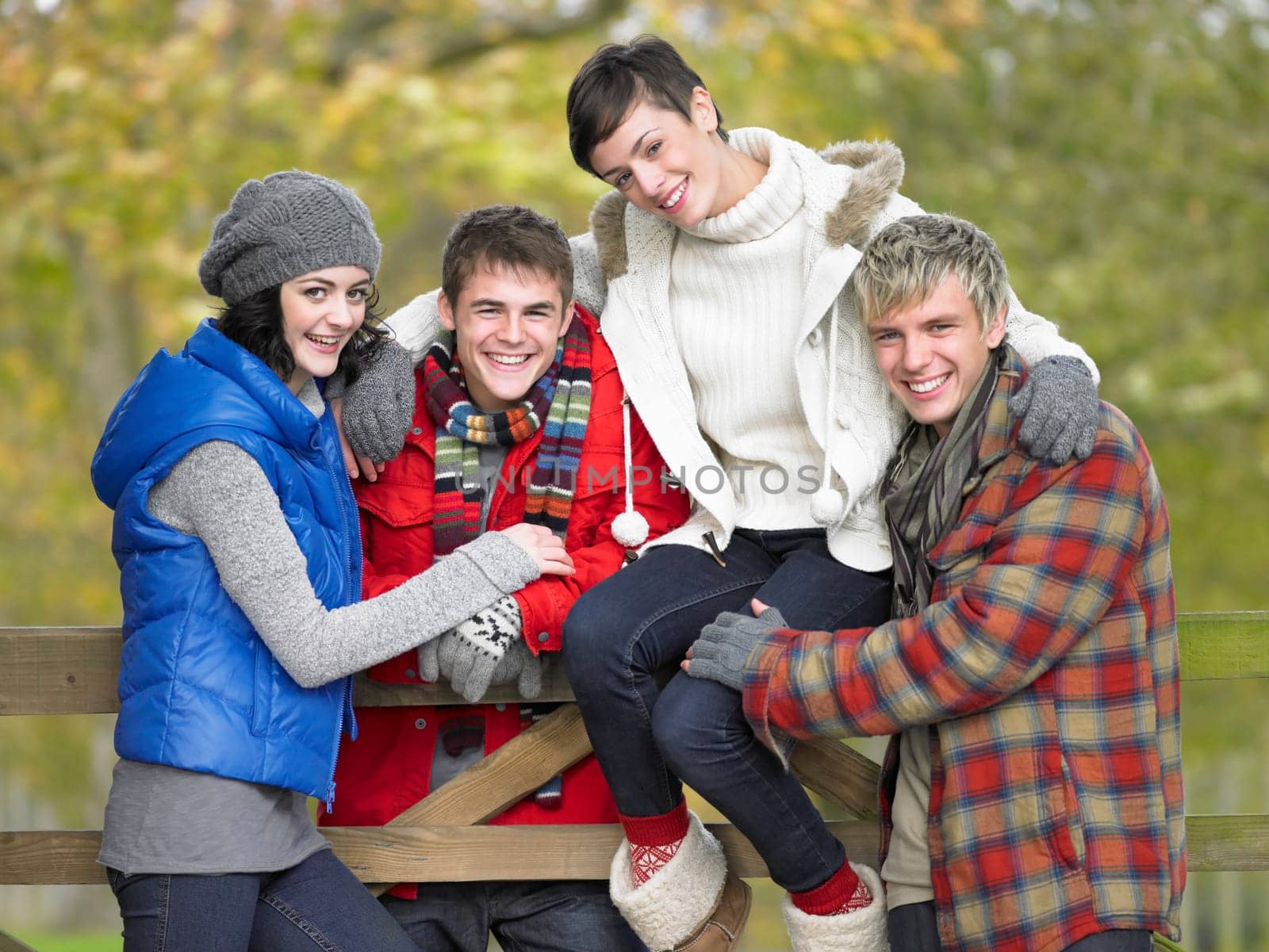 Young friends sitting on fence