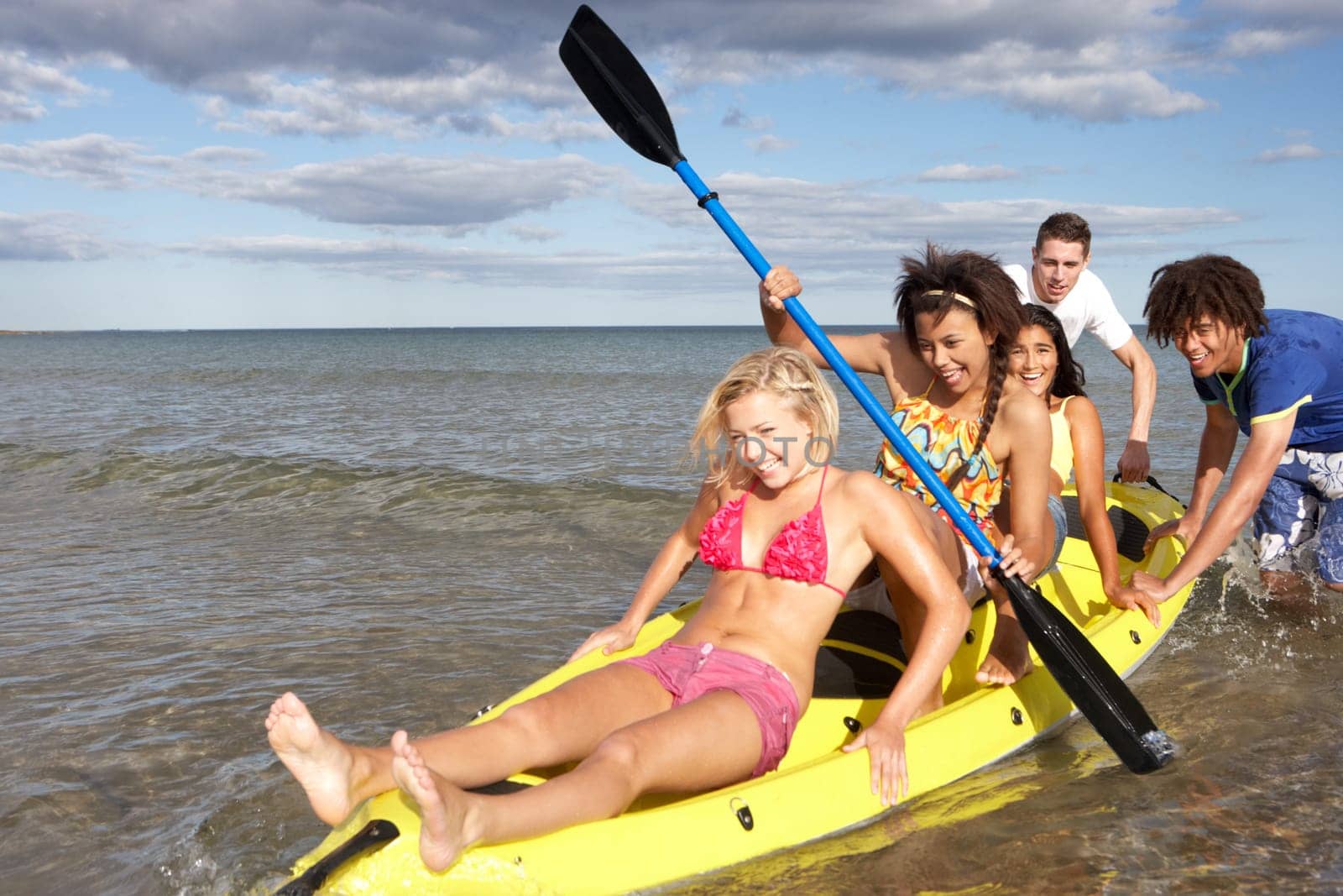 Teenagers in sea with canoe