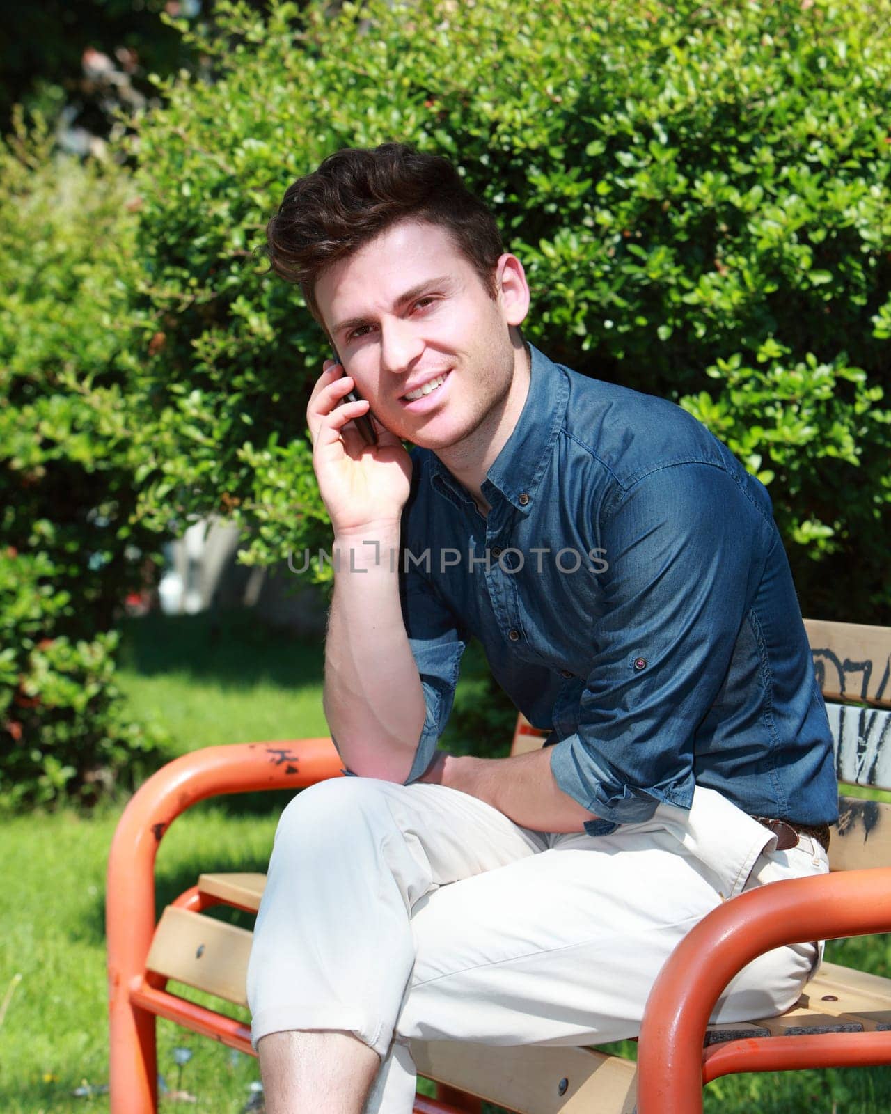 Relaxed handsome russian man in park calling
