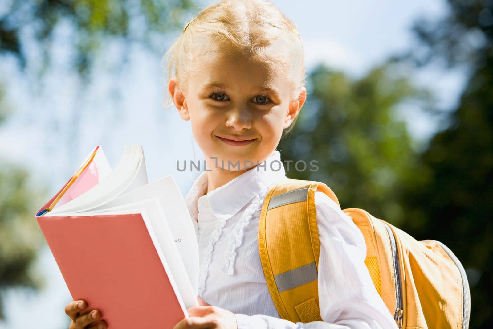 Portrait of happy young schoolgirl looking at camera