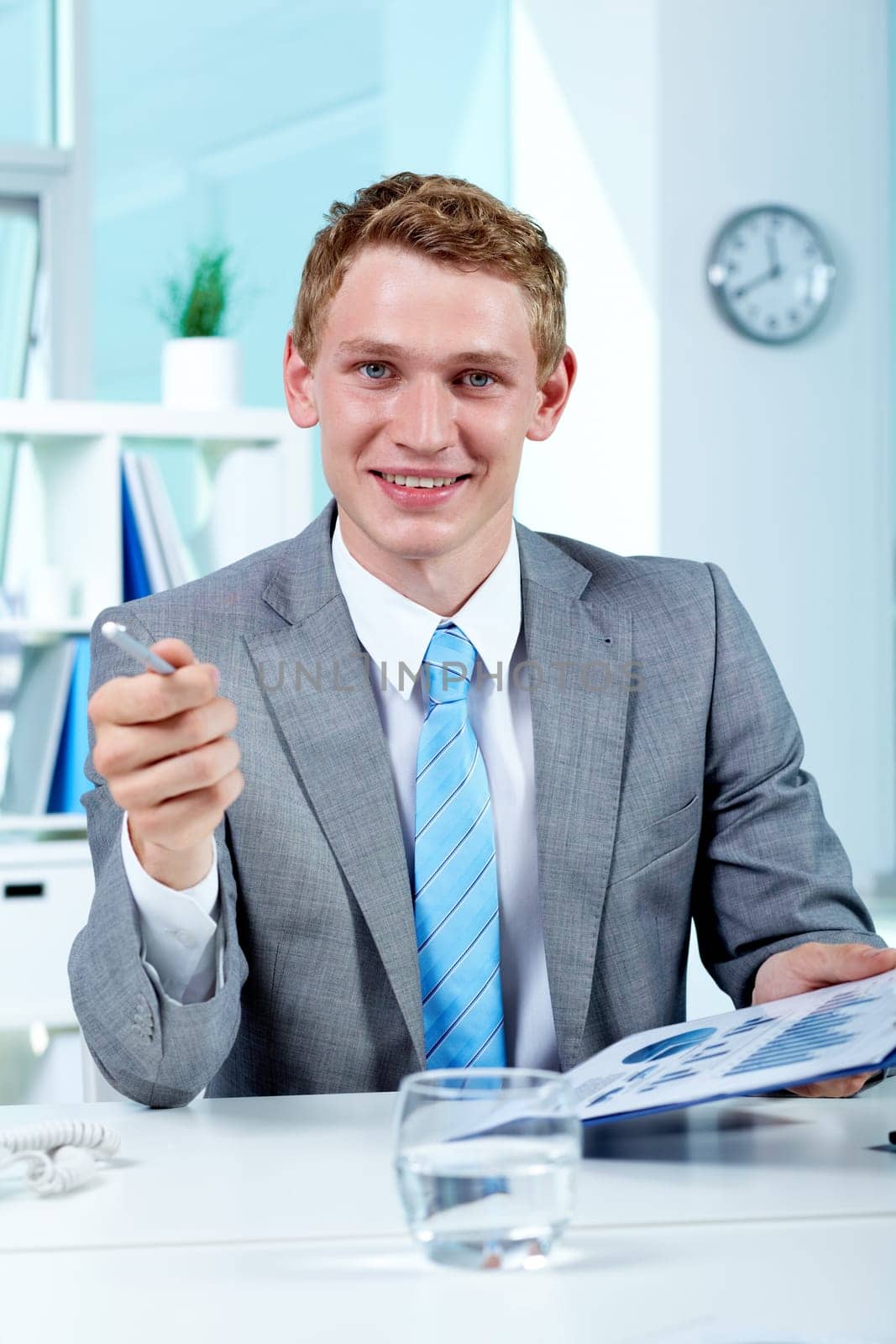 Portrait of a successful employer with document looking and pointing at camera