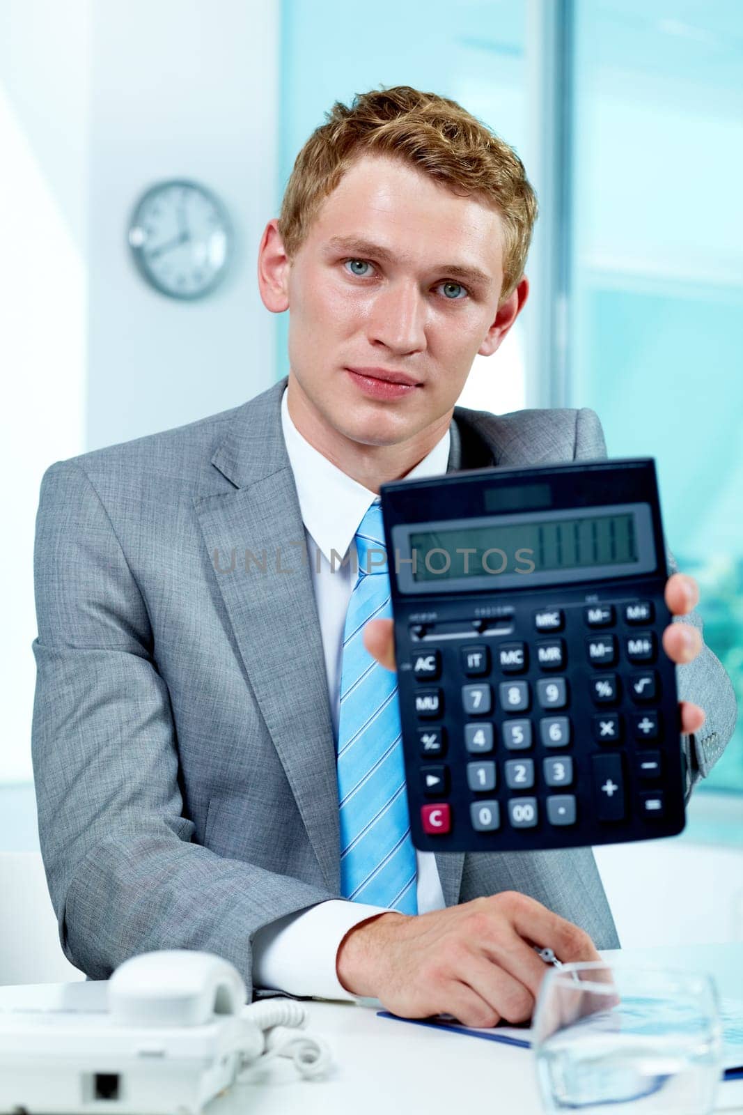 Portrait of a successful employer with calculator looking at camera