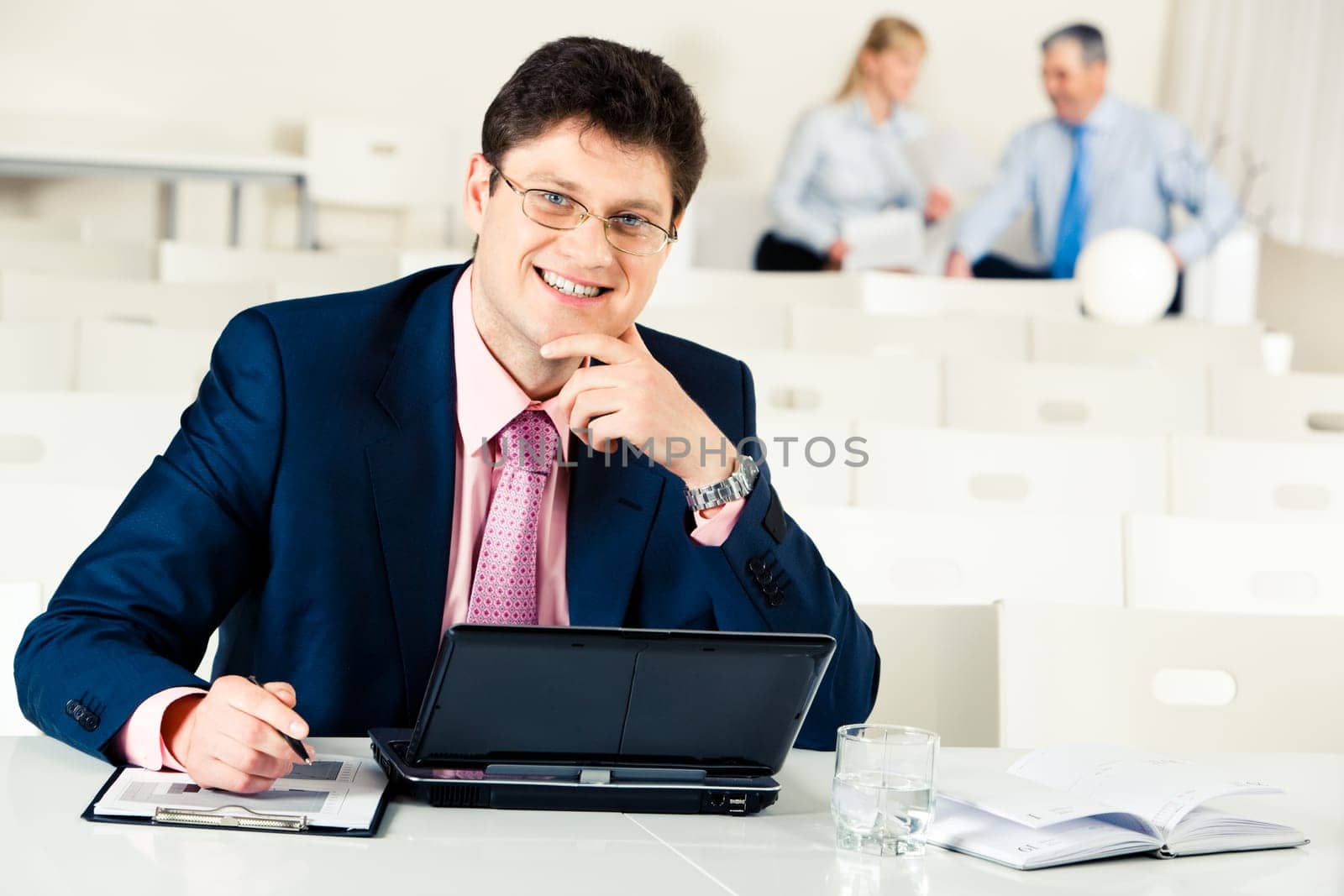 Photo of confident businessman working at laptop on the background of his partners