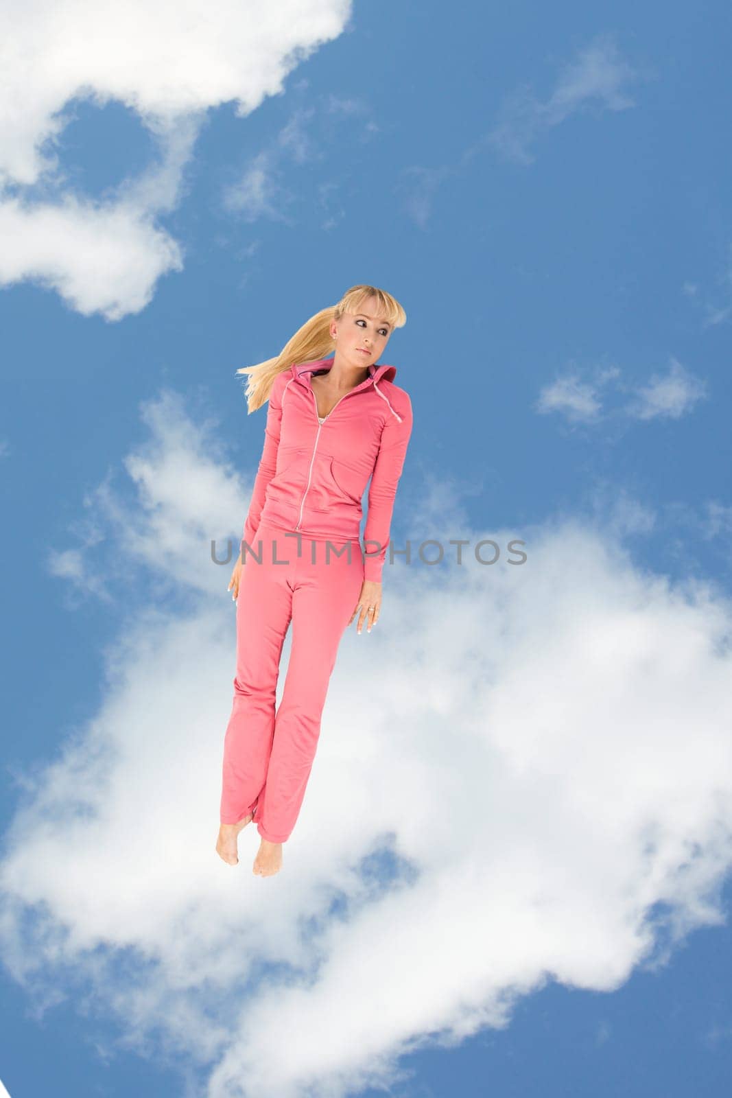 Creative image of sporty girl keeping straight on background of cloudy sky