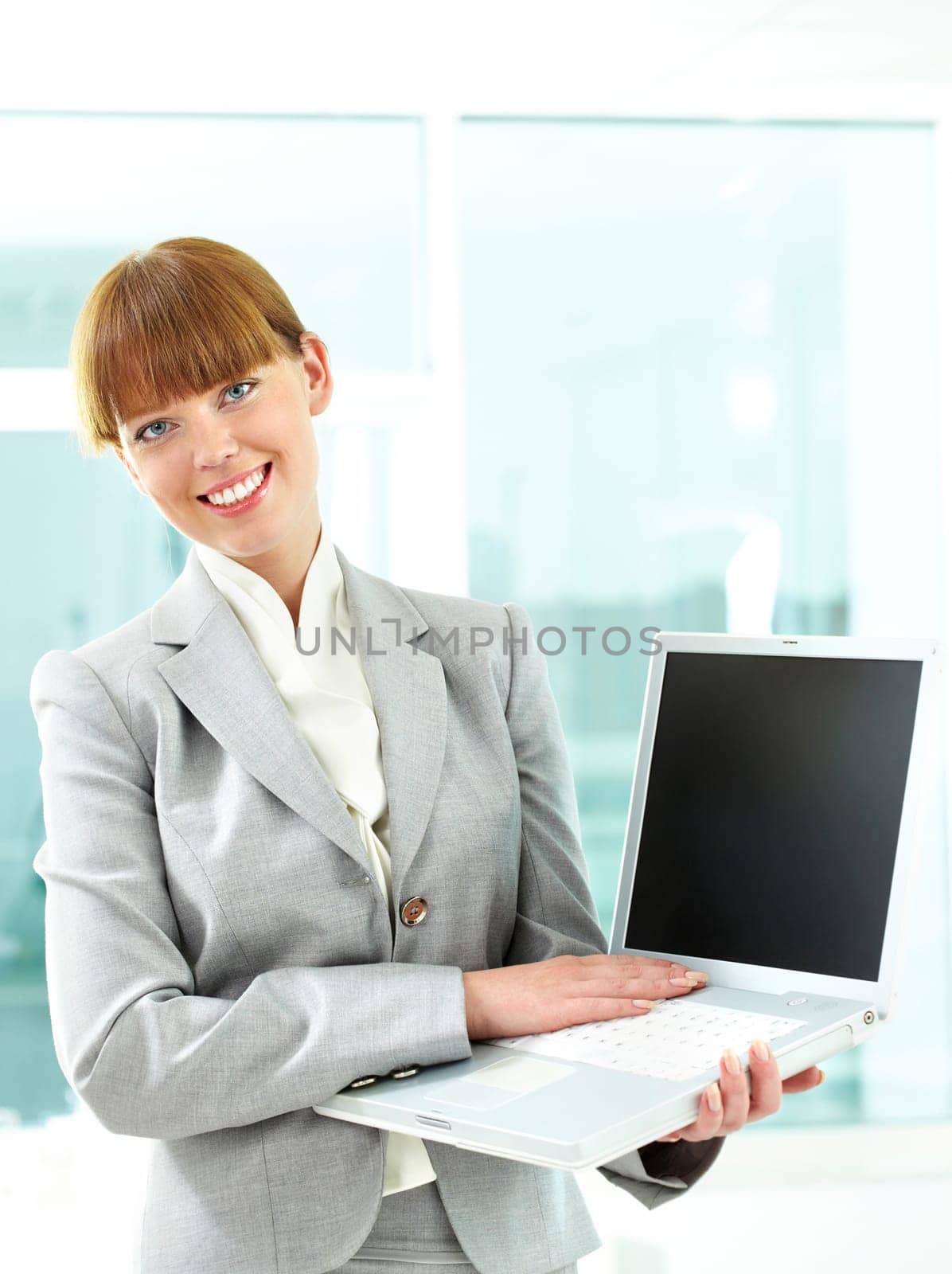 Portrait of successful business lady with open laptop in hands