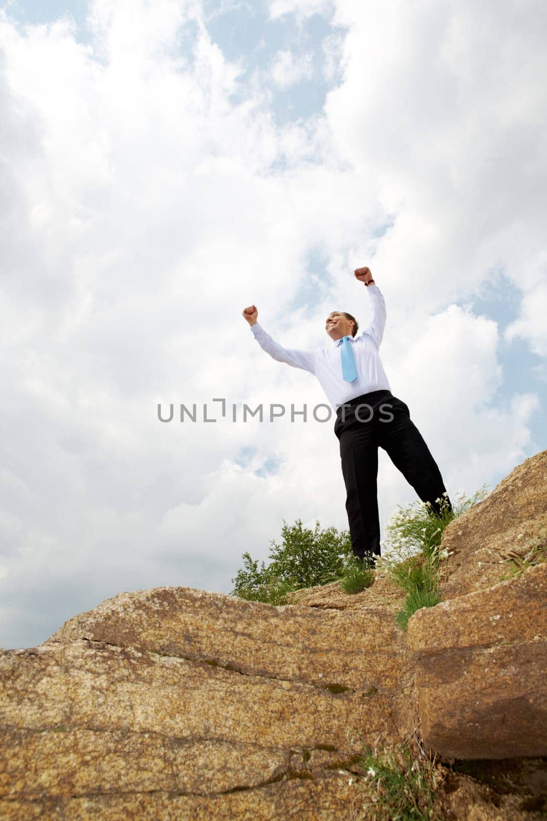 Photo of relaxed businessman standing and raising his arms outdoors in summer