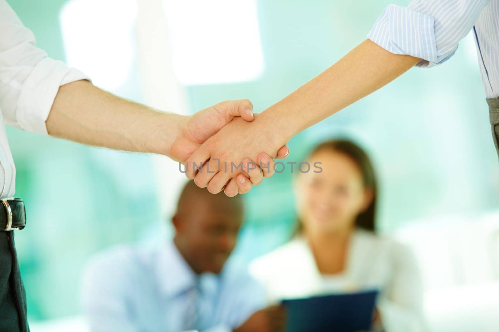 Shaking hands in office against business people
