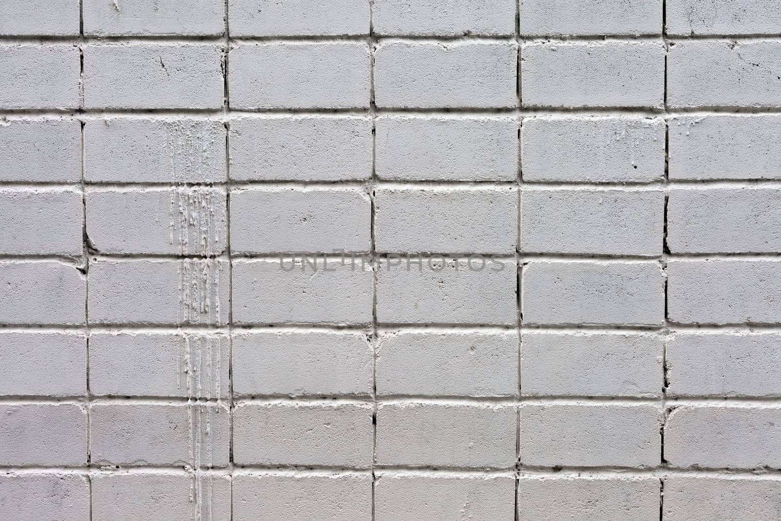 white roughly textured brick wall painted with white paint