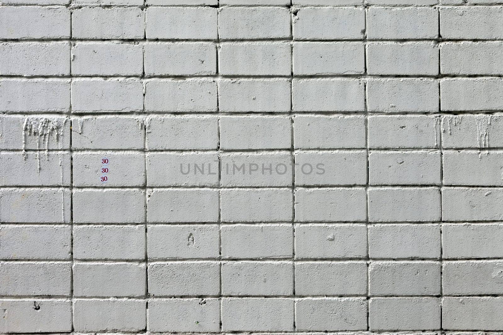 white roughly textured brick wall painted with white paint