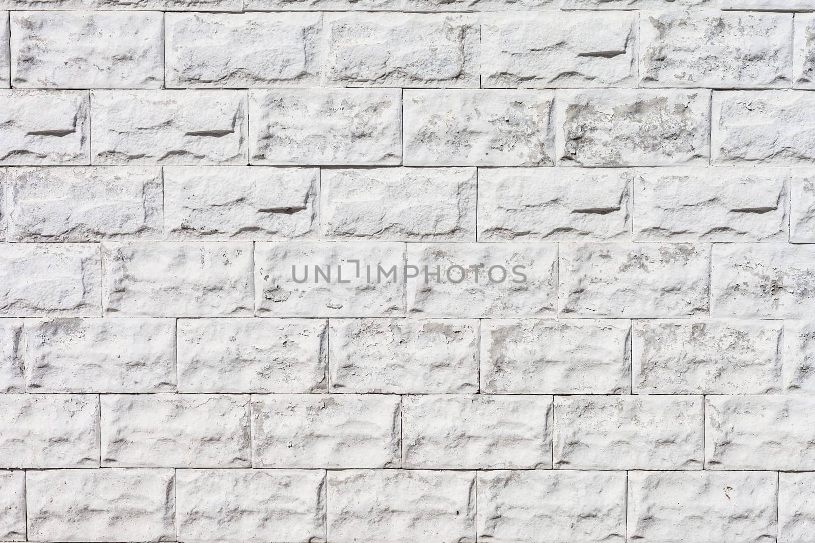 white roughly textured brick wall painted with white paint
