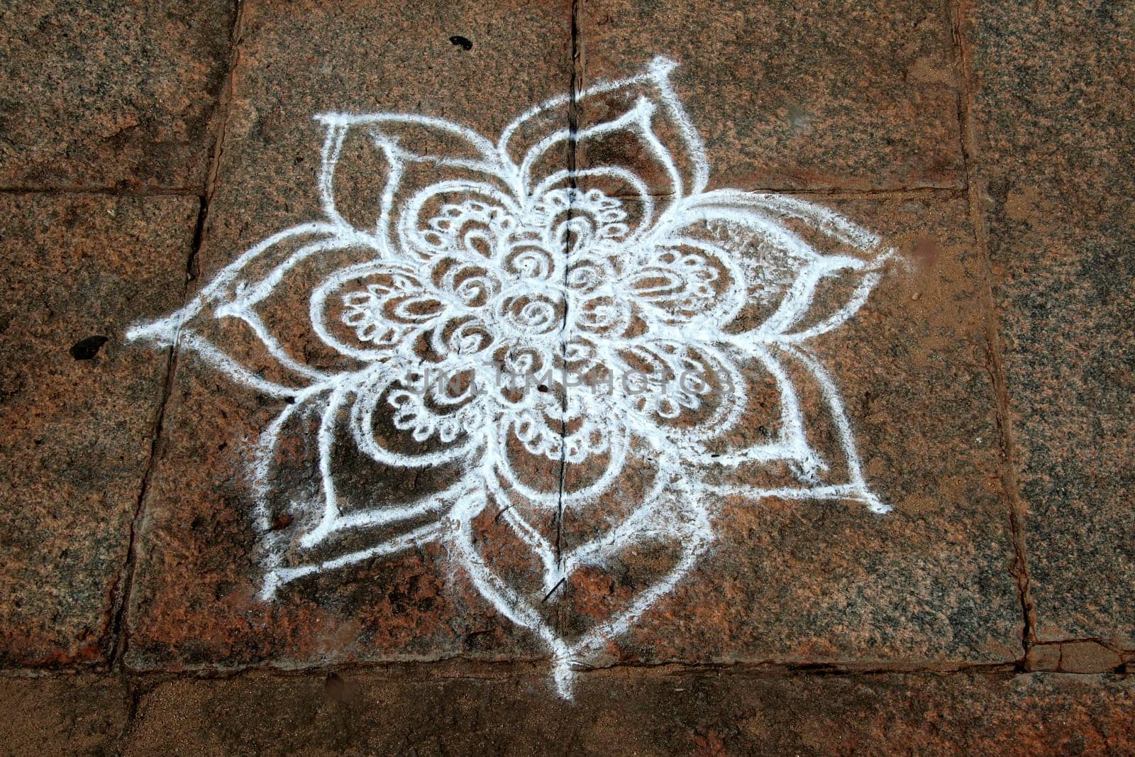 Skillful Rangoli artwork using white stone powder