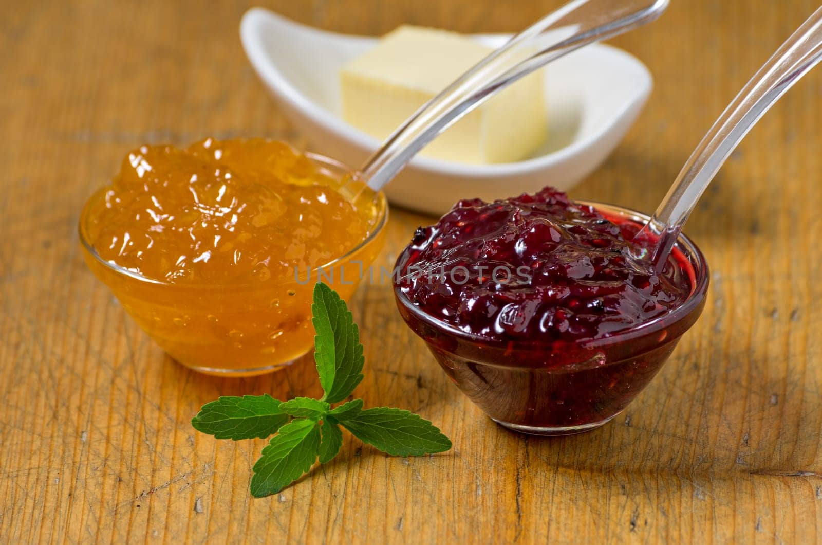 Jam with stevia leaves on wooden board