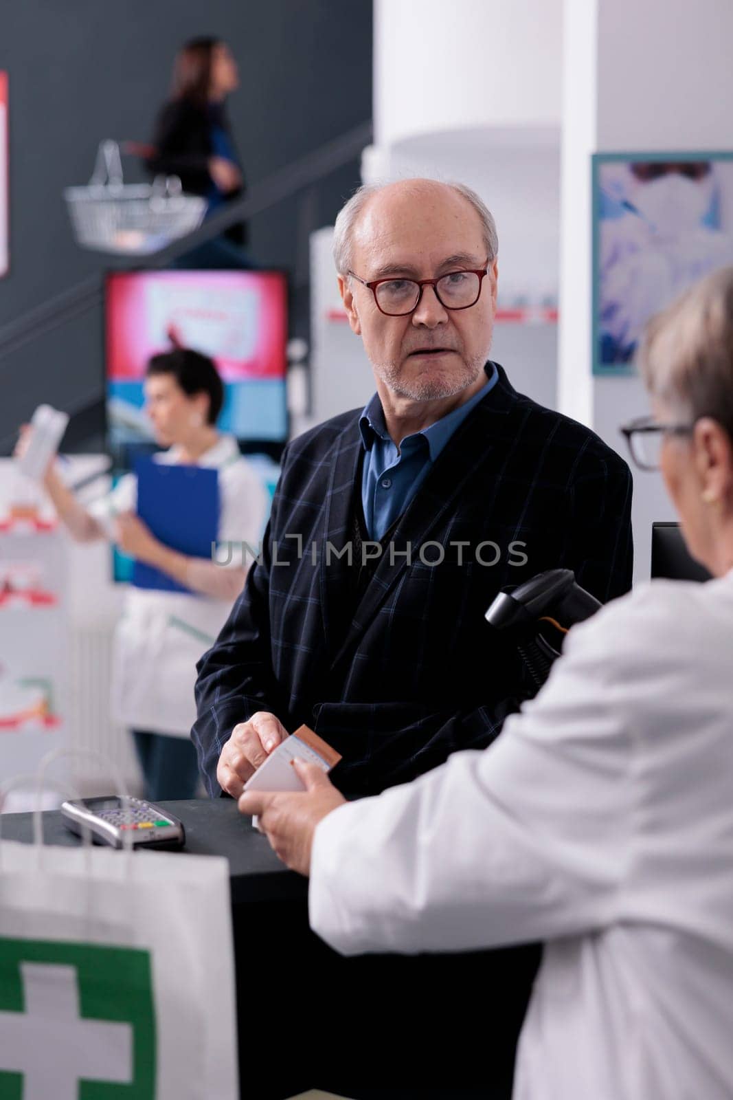 Old man asking pharmacy cashier to scan sunscreen price by DCStudio