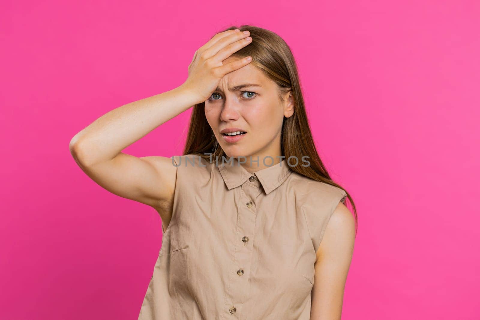 Face palm. Shame on you. Upset Caucasian young woman making face palm gesture, feeling bored, disappointed in result, bad news, sorrowful. Unhappy girl isolated on pink studio background indoors