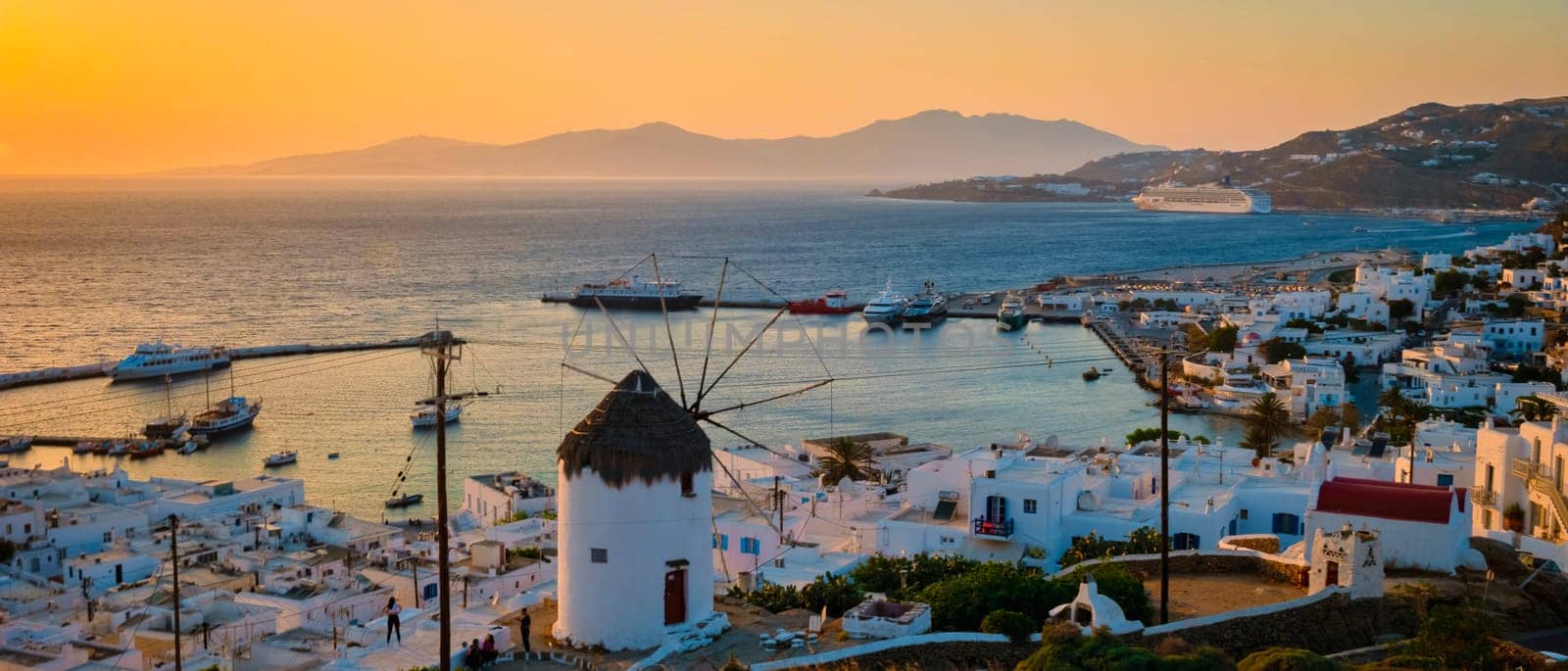 Sunset on the hills of Mykonos Greek village in Greece, the colorful old town of Mikonos village with historical windmills