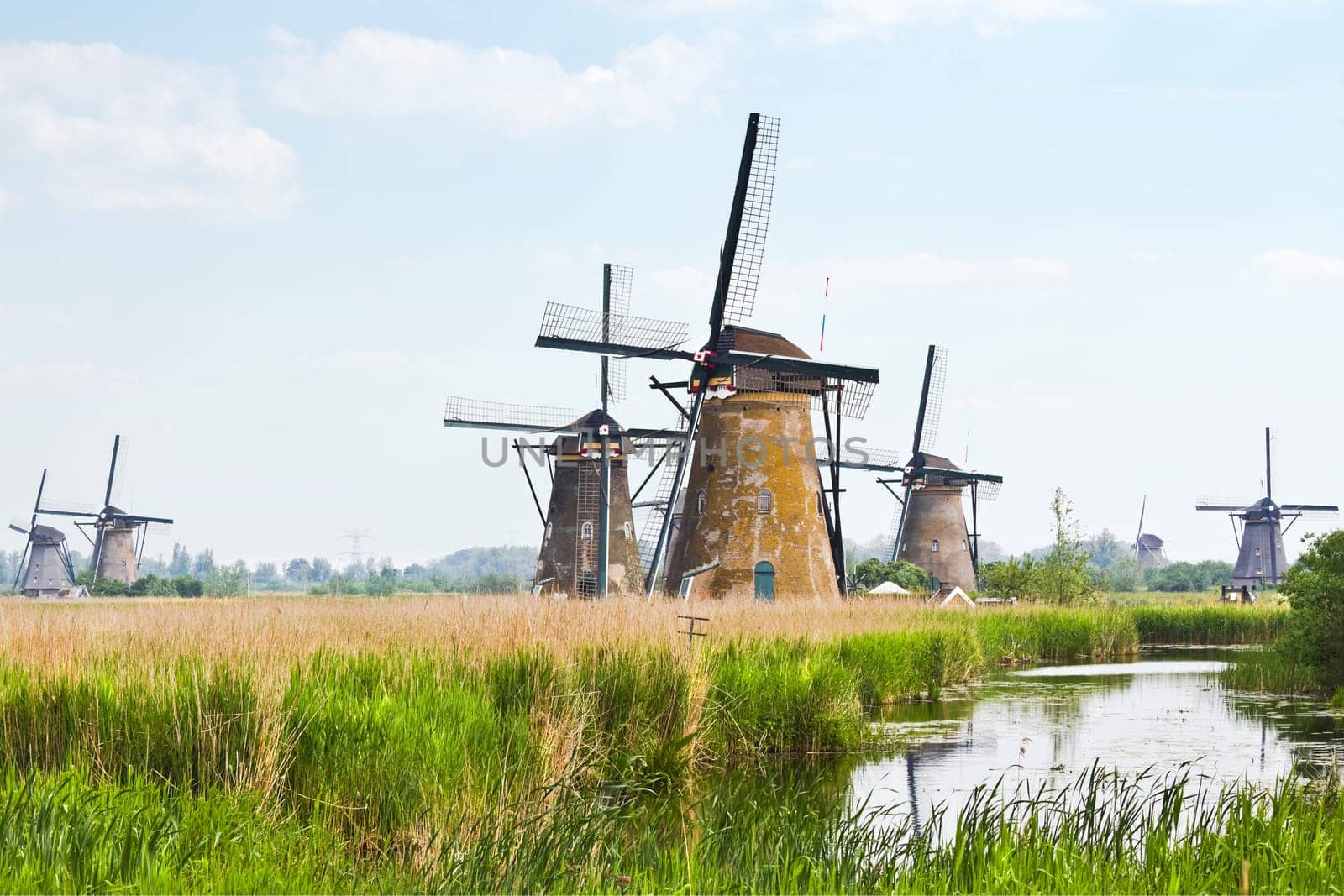 Dutch countrylandscape in Kinderdijk, the Netherlands with eight from the nineteen windmills on hazy day