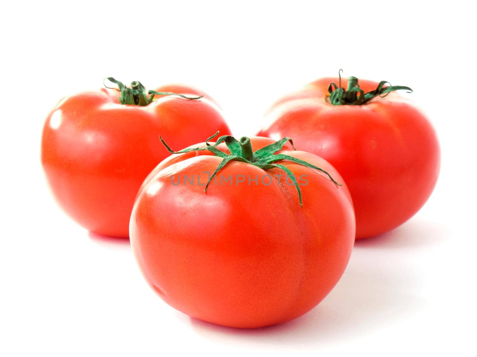Three fresh red tomatoes isolated on white background
