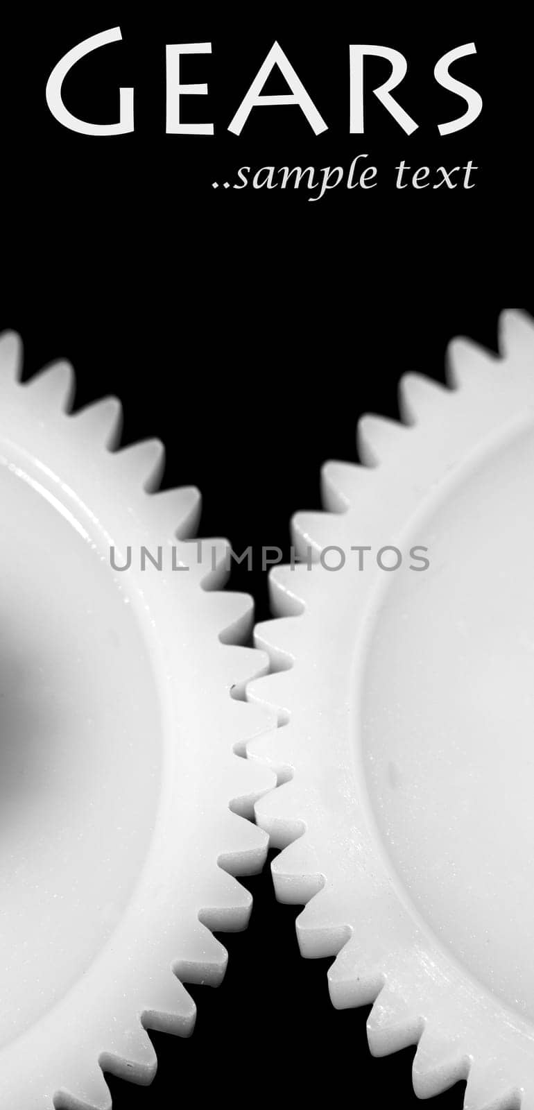 Two white connected cogwheels on black background