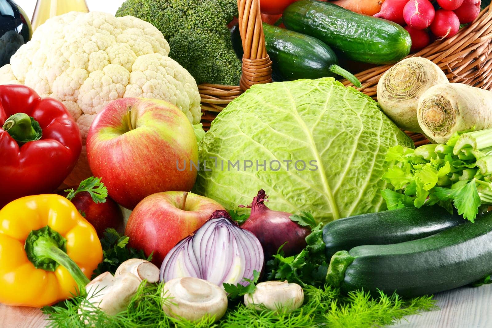 Composition with wicker basket and grocery isolated on white