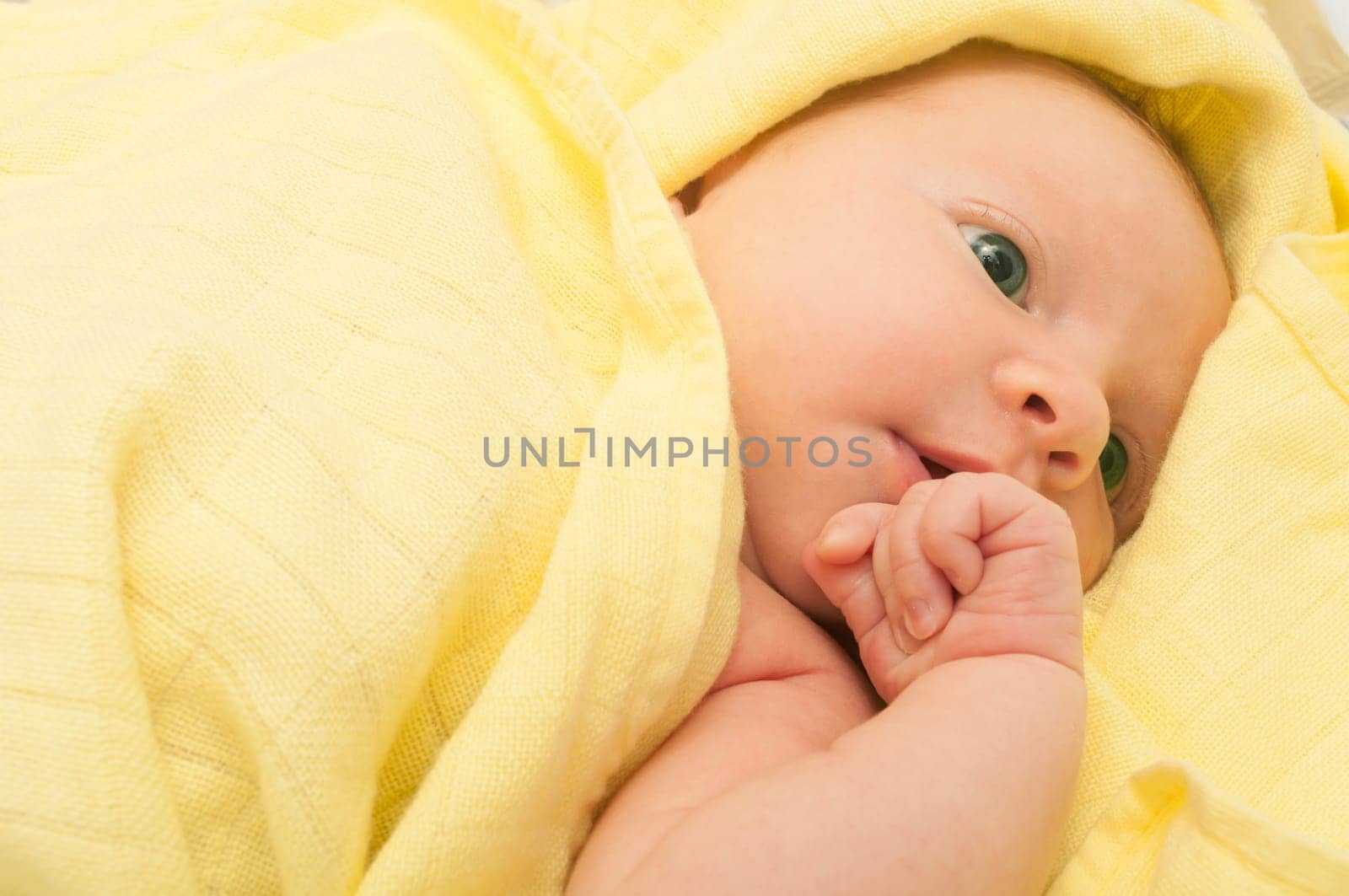 Newborn Baby in the Bed under Yellow Blanket