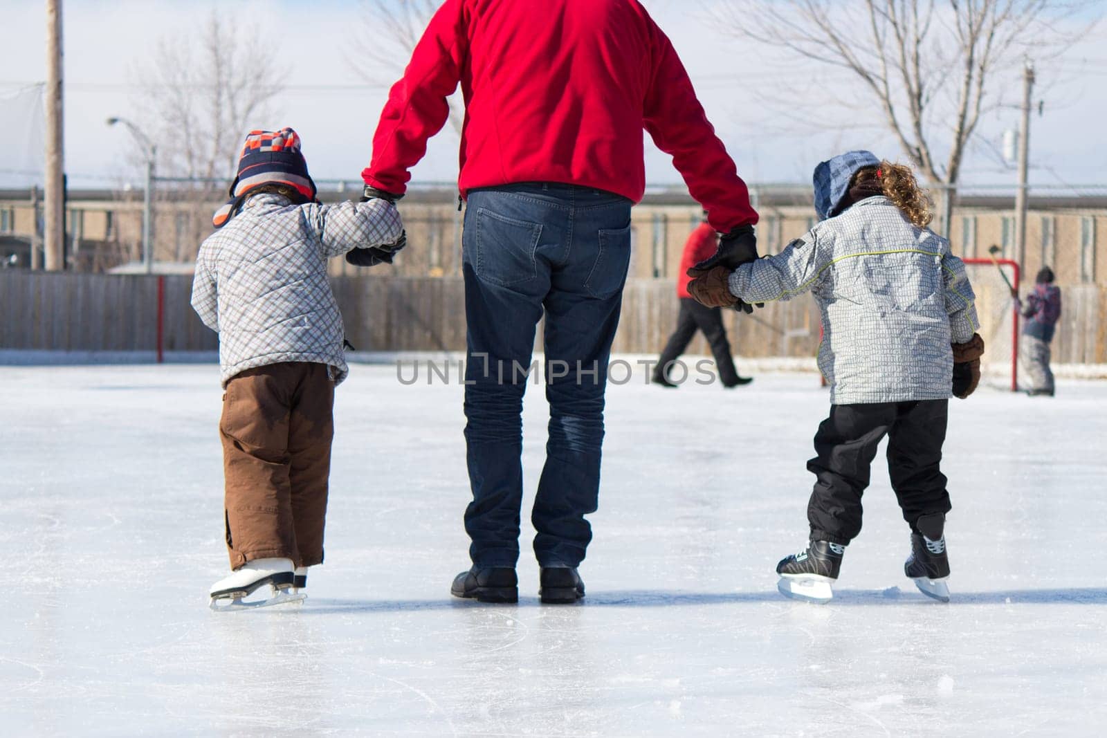 Family having fun at the outdoor skating rink in winter.