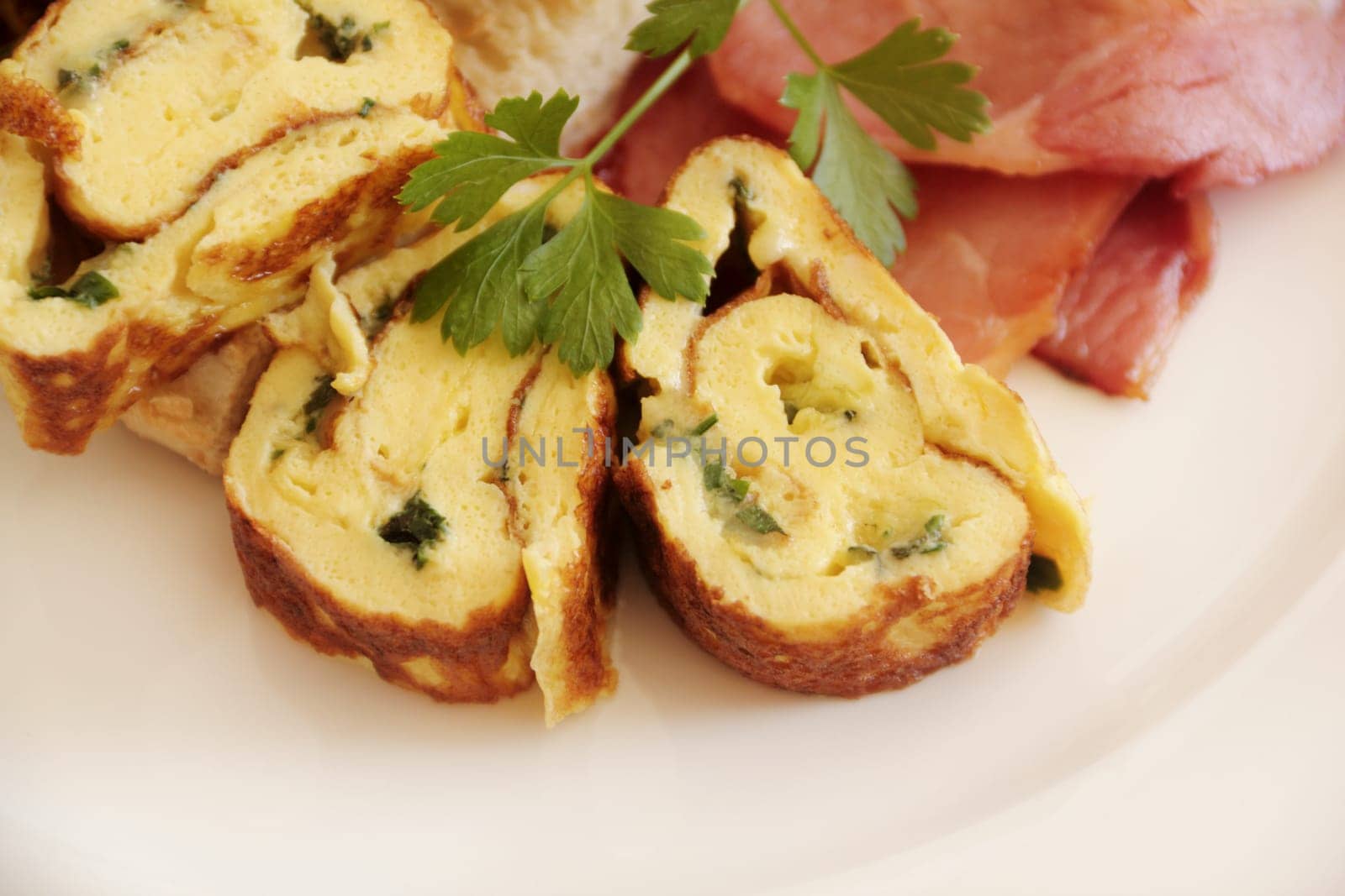 Delicious sliced rolled omelette with bacon and Turkish bread with parsley.
