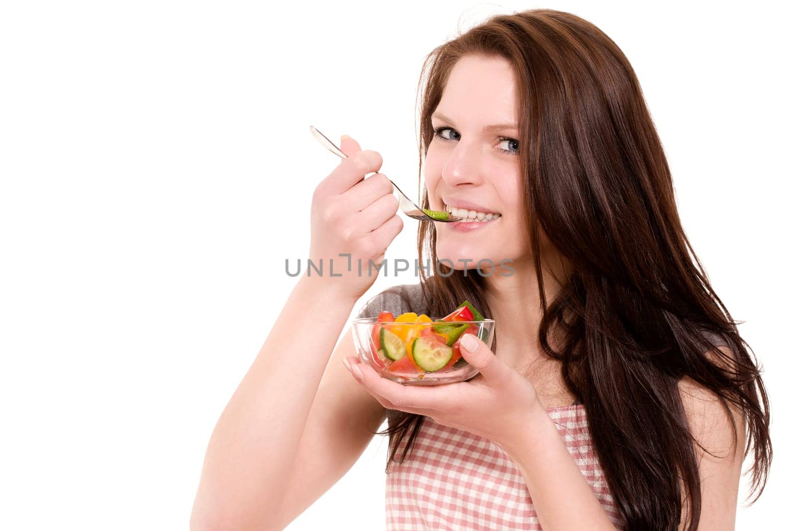 Young happy woman eating salad against white background