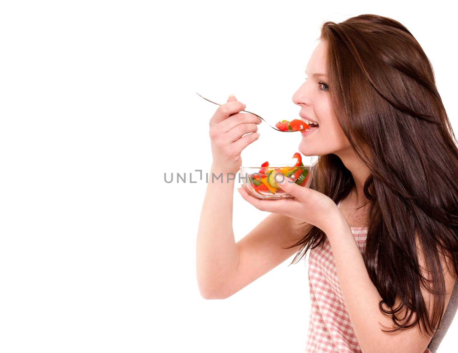Happy young woman eating salad against white background