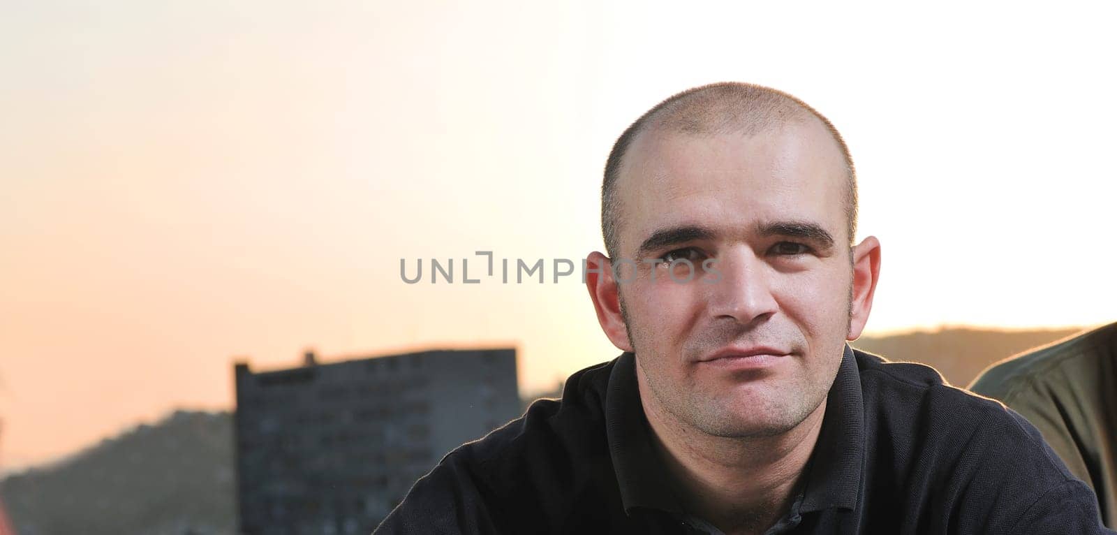 happy young man posing outdoor in urban enviroment with graffiti in background