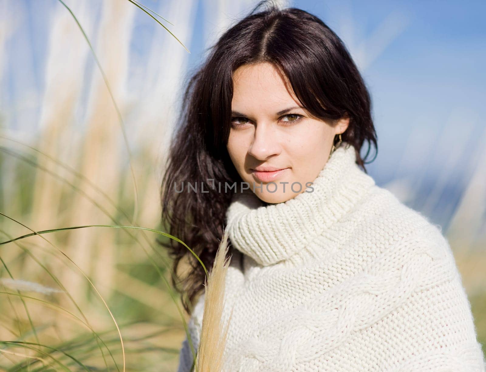 young beautiful woman in the nature with the grass and the sky as a background