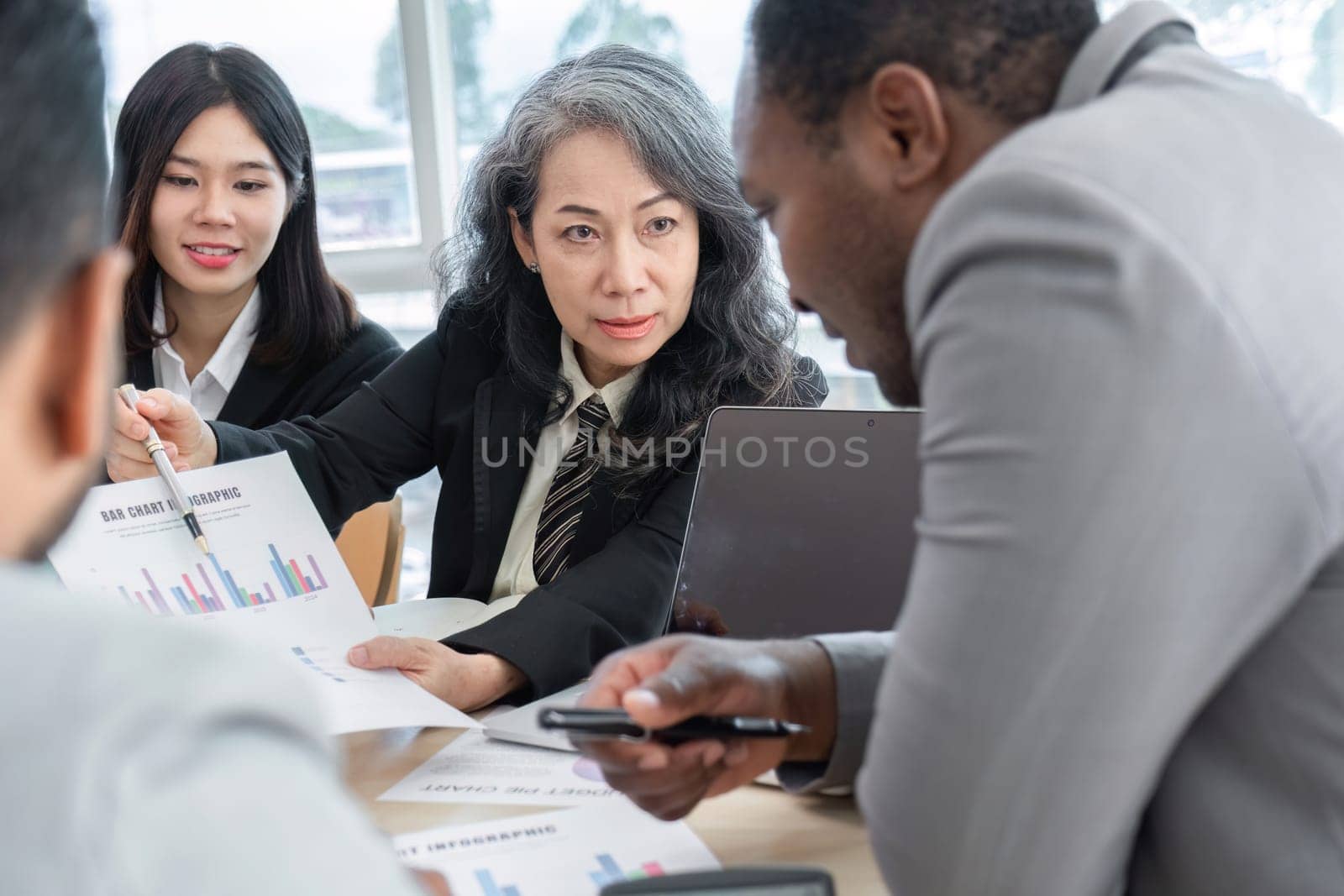 Business People Meeting using laptop computer,calculator,notebook,stock market chart paper for analysis Plans to improve quality next month. Conference Discussion Corporate Concept by wichayada