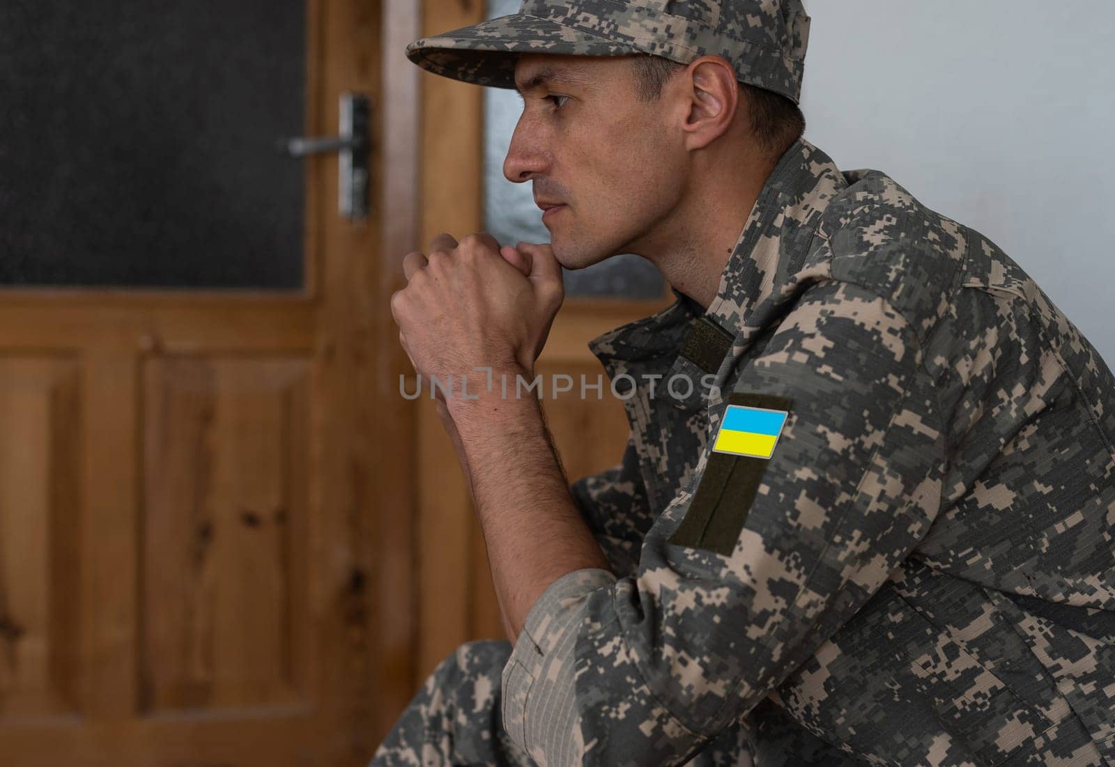 Ukrainian soldier wearing military uniform with flag and chevron depicting trident - Ukrainian national symbol flag by Andelov13