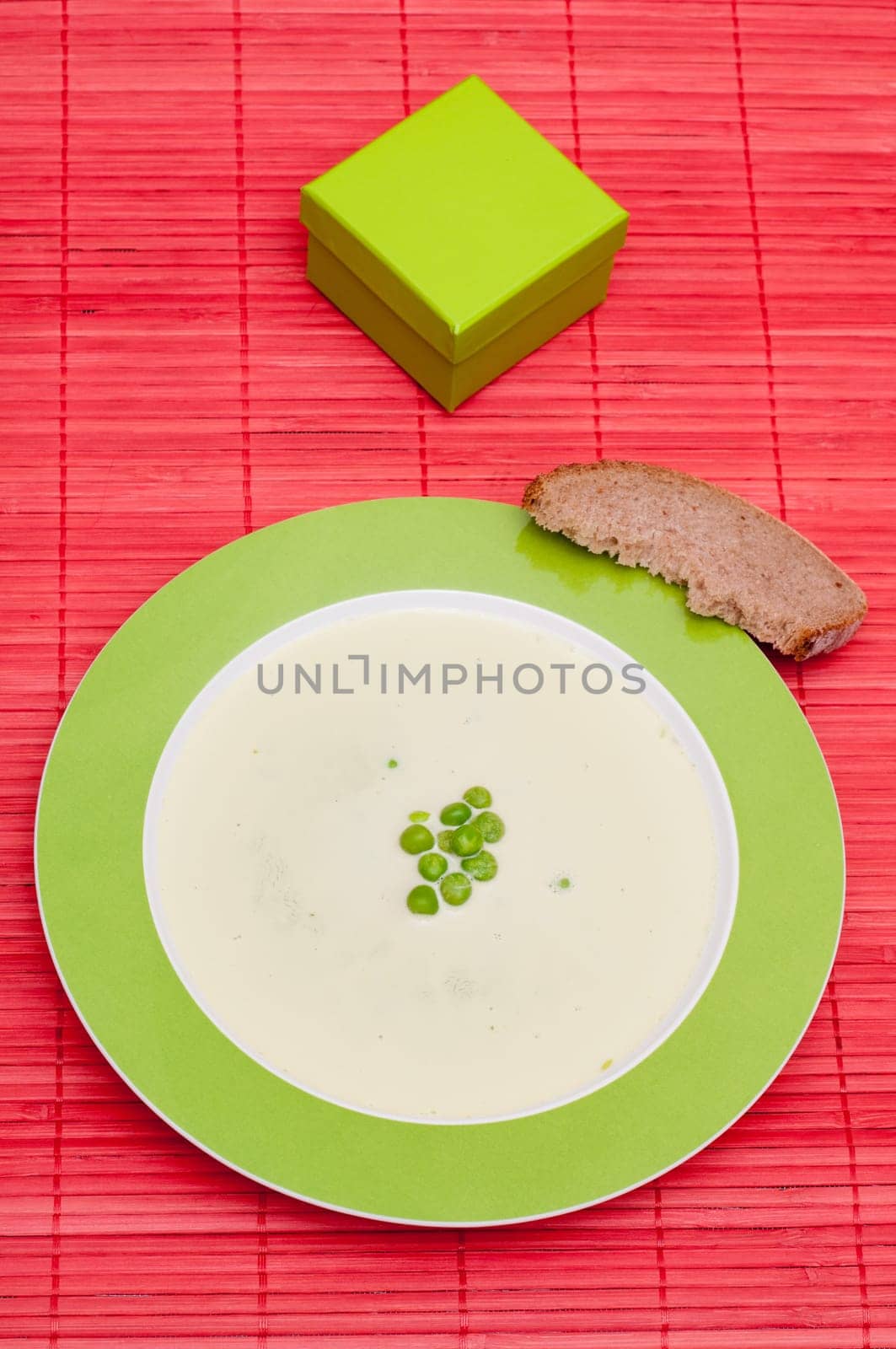 Soup with green peas and a slice of bread
