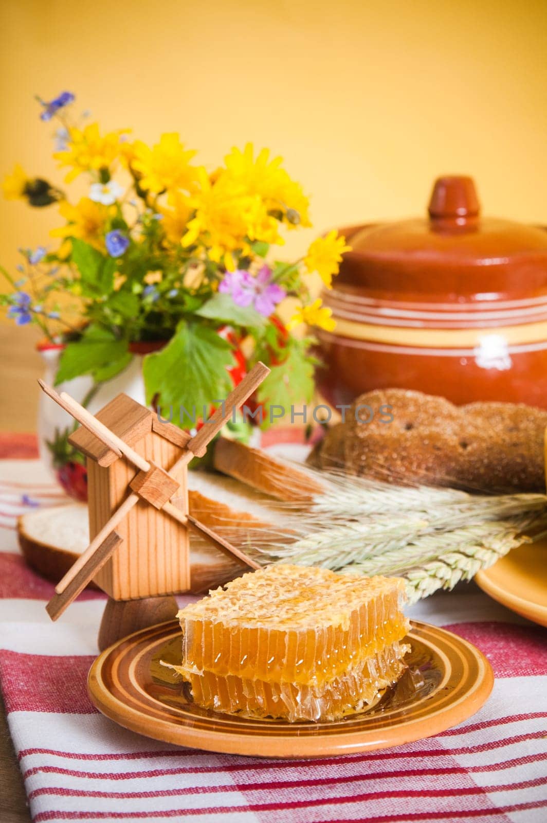 Still life with honeycombs, flowers and pot