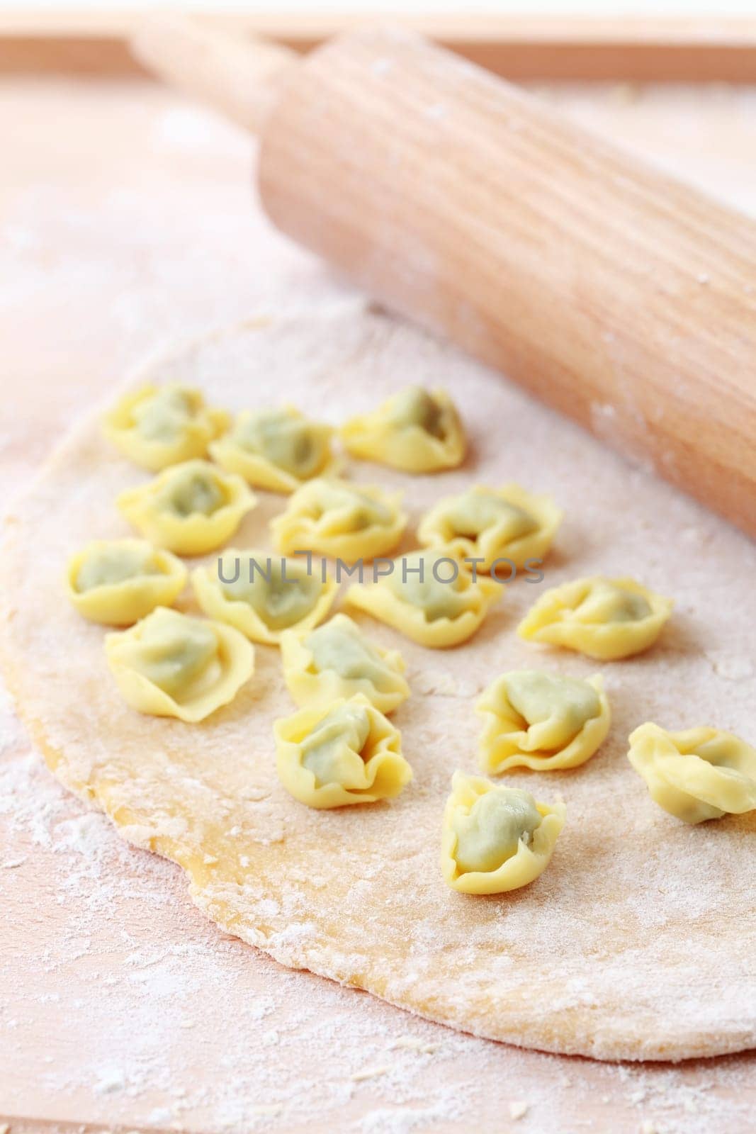 Dough with raw tortellini and rolling pin
