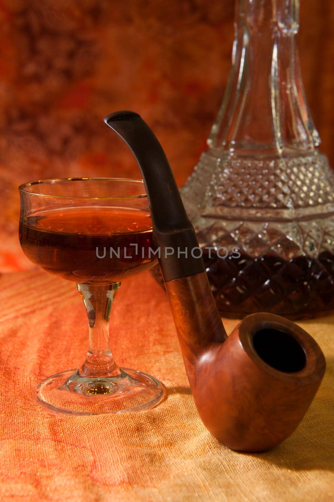 Pipe, Glass and bottle of brandy on a colored background