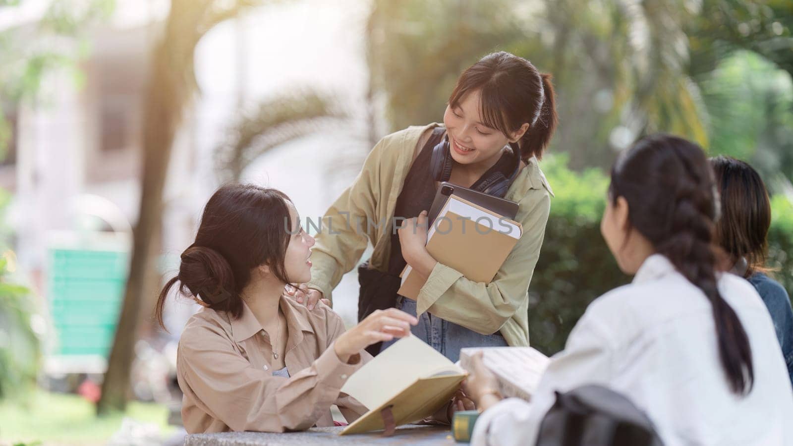 Group of friends meet in the park in university. People having breaking time outdoor. young woman greet college.