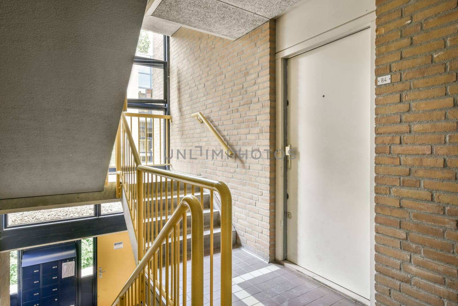 the outside of a building with stairs leading up to an open door that leads to a small balcony and patio