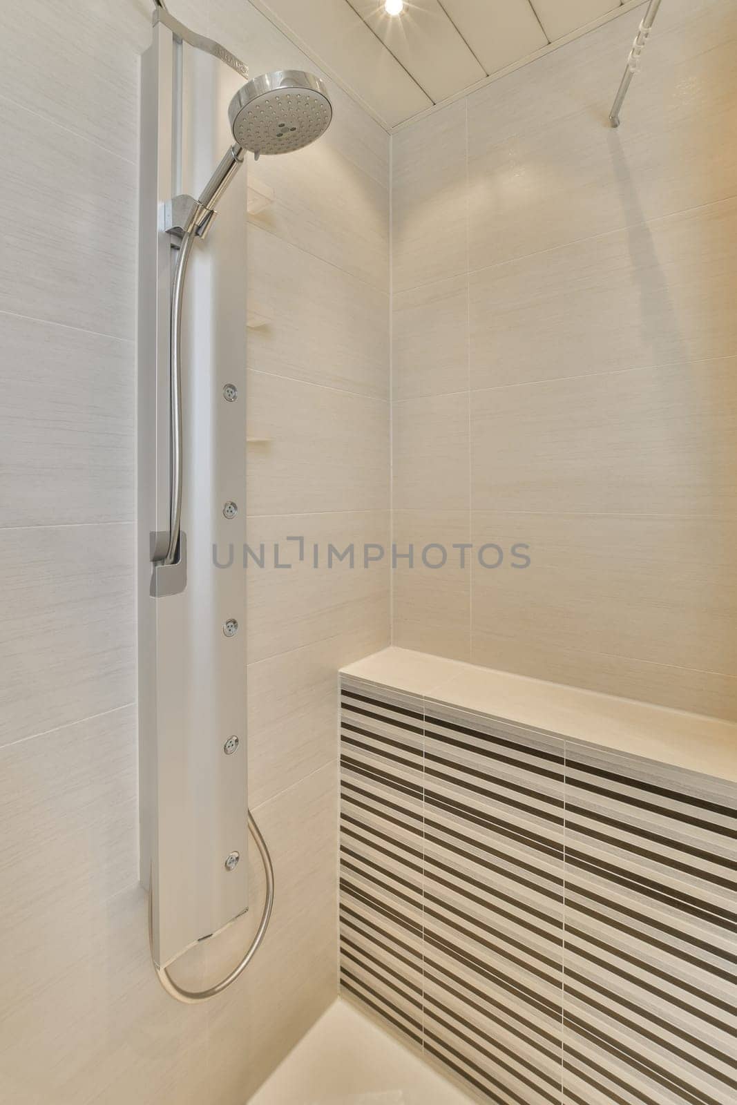 a bathroom with white tiles on the walls and shower head mounted to the wall in front of the bathtub