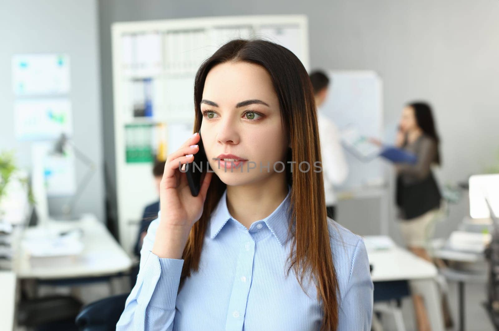 Portrait of smart lady using modern gadget to talk with witty colleagues on big distances. Gorgeous young manager discussing questionable business topic. Company meeting concept