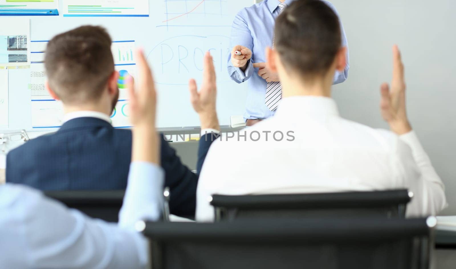 Focus on hand pointing to person wanting to ask something. Workers sitting at office in conference room. Company and business meeting concept. Blurred background