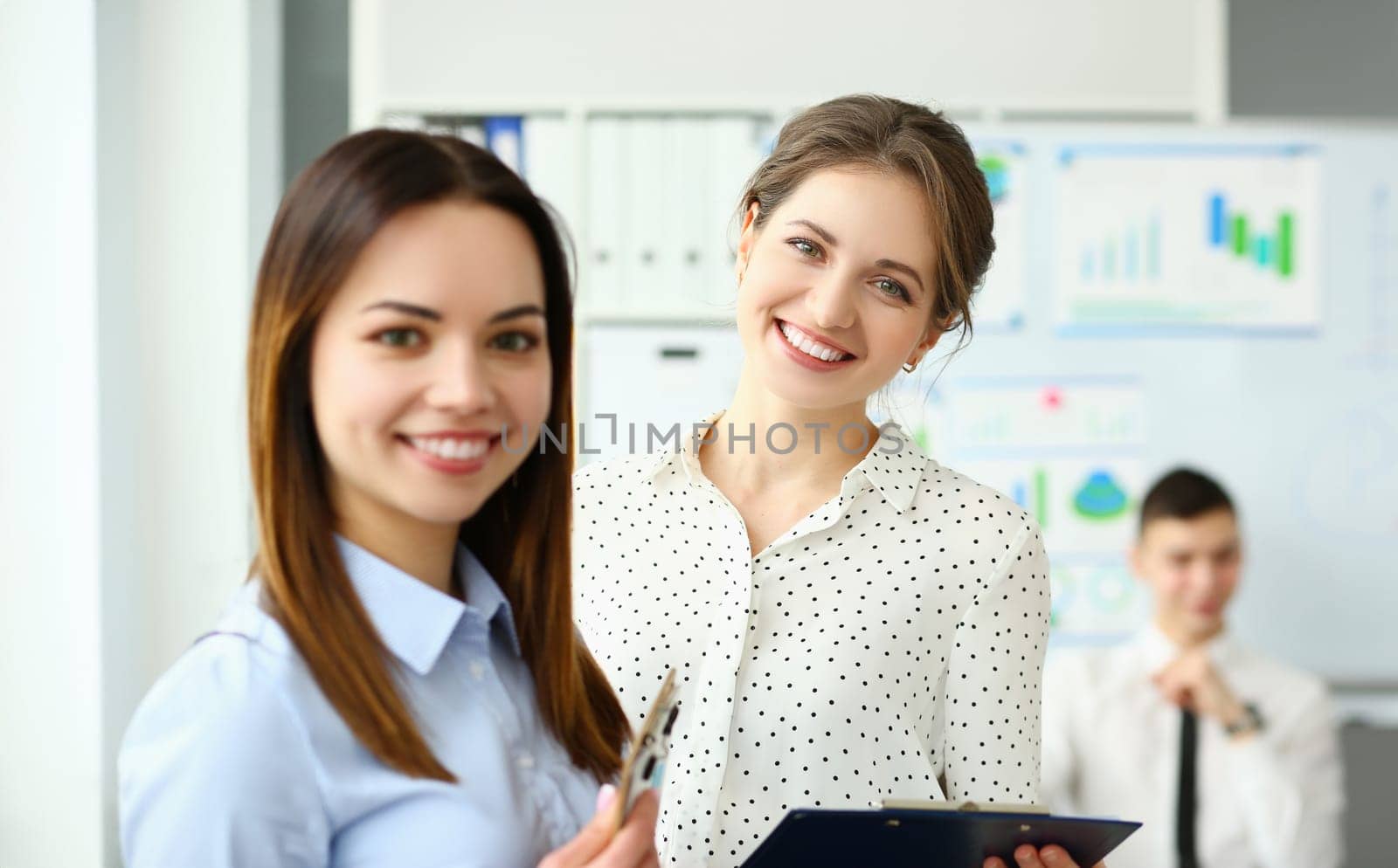 Portrait of smart female holding paper tablet with important business contract. Gorgeous lady in classy blouse looking at camera with great joy and calmness. Company meeting concept