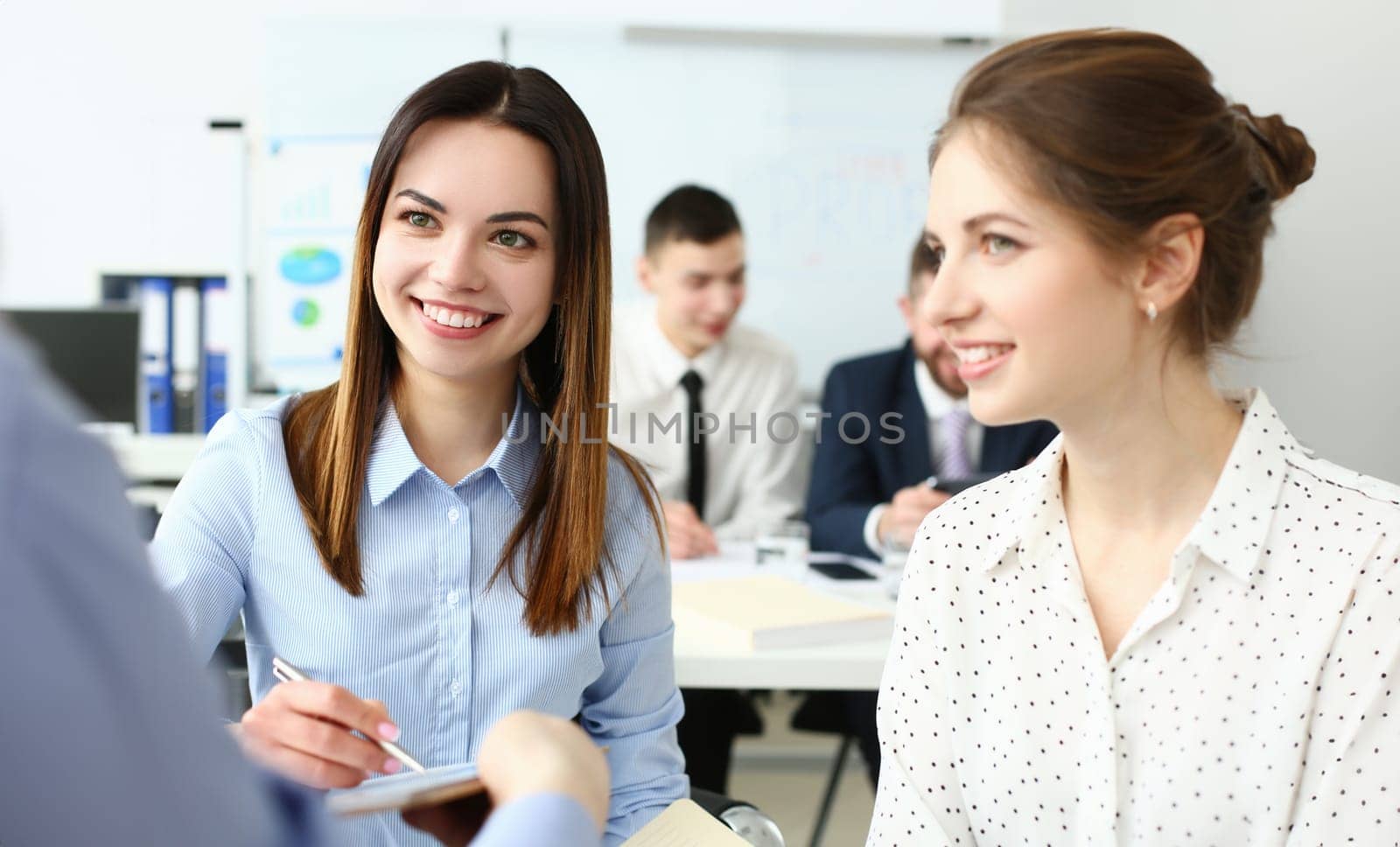 Portrait of gorgeous woman sitting in big modern building and talk about new business strategy that can highly increase corporation income. Company meeting concept