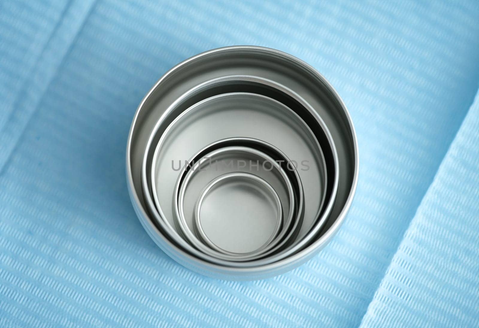 Medical and cosmetic metal jars on blue. Round cosmetic cream packaging mockup