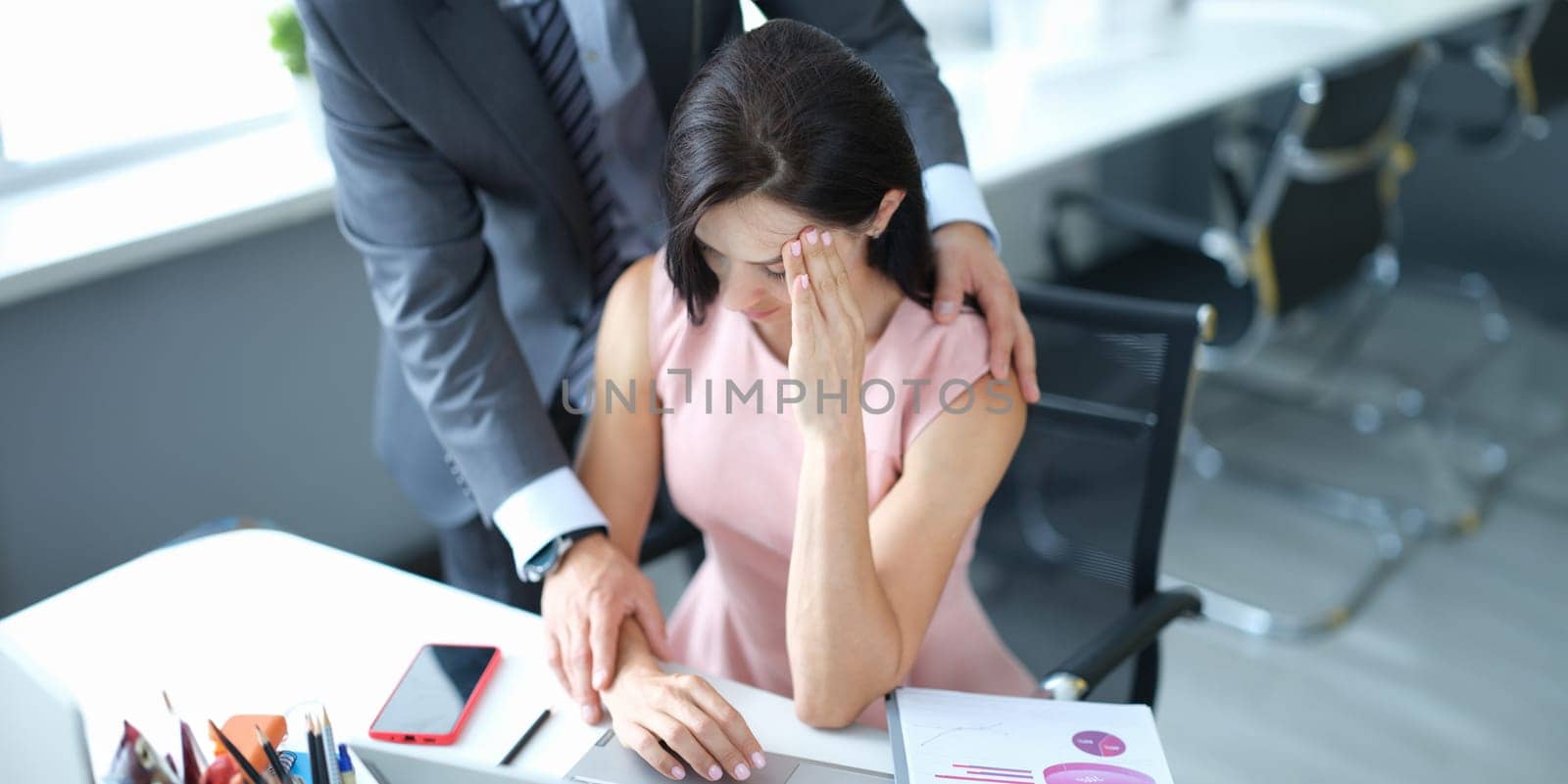 Businessman pestering female colleague in the workplace. Harassment at work concept