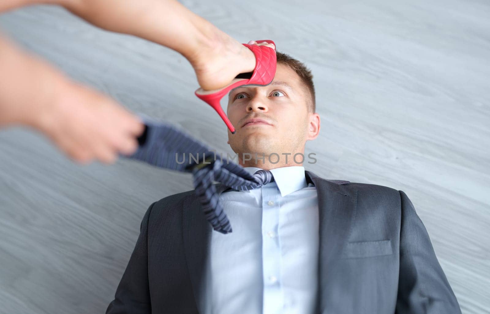 Woman foot in high-heeled shoes stands on man head. Domination of women over men concept